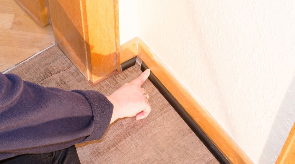 person checking the baseboard