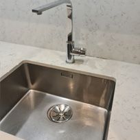 polished and streak free stainless steel sink and tap with stone countertop limescale removed